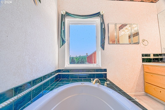 bathroom with a tub and vanity