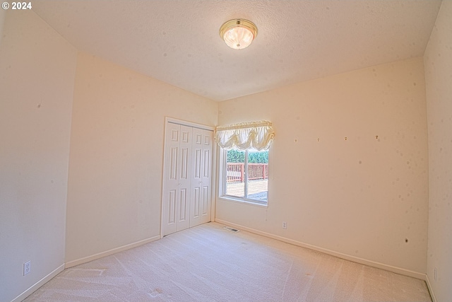 empty room featuring carpet and a textured ceiling