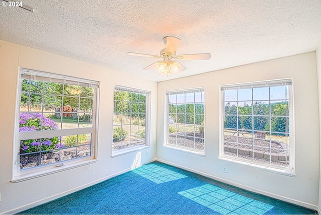 unfurnished sunroom with ceiling fan