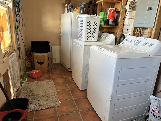 washroom featuring separate washer and dryer, electric panel, and dark tile patterned floors