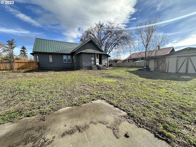 back of house with a yard and a shed