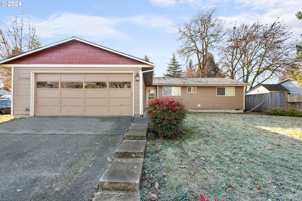 ranch-style house featuring a garage and a front lawn