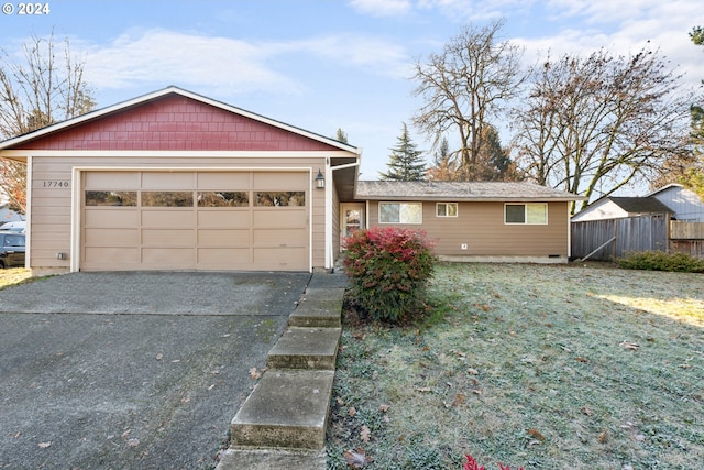 ranch-style house featuring a garage and a front lawn