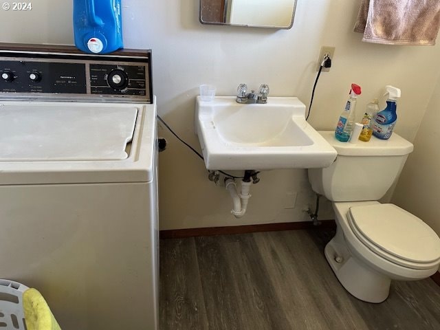 bathroom with hardwood / wood-style floors, sink, washer / clothes dryer, and toilet