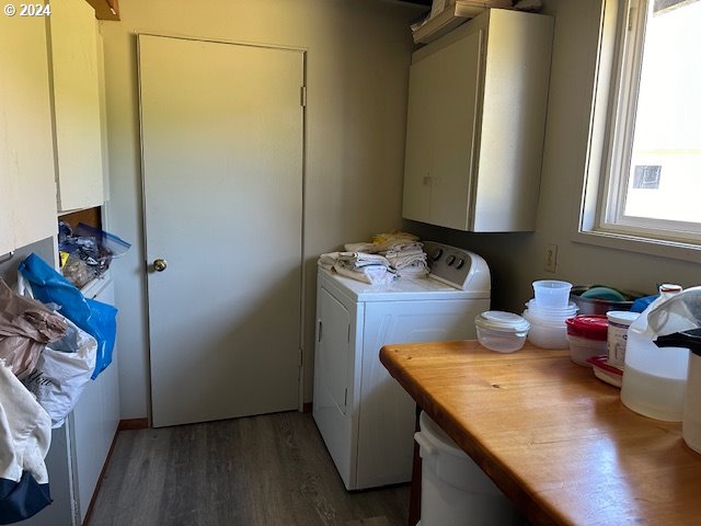 laundry area with dark hardwood / wood-style flooring, cabinets, and washer and clothes dryer