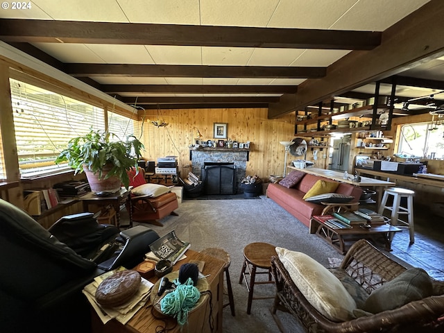 interior space with a fireplace, beamed ceiling, wooden walls, and carpet flooring