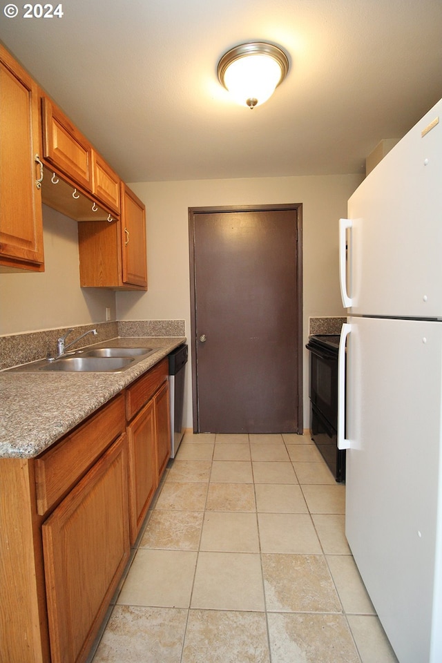 kitchen featuring black electric range oven, sink, light tile patterned floors, white refrigerator, and stainless steel dishwasher