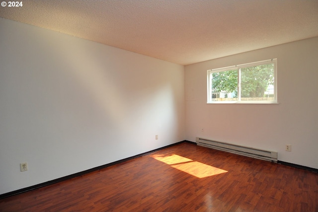 spare room featuring dark hardwood / wood-style flooring, a textured ceiling, and baseboard heating