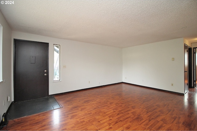 foyer with dark hardwood / wood-style floors and a textured ceiling