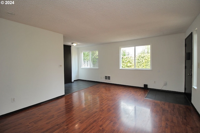 unfurnished room featuring dark hardwood / wood-style flooring and a textured ceiling