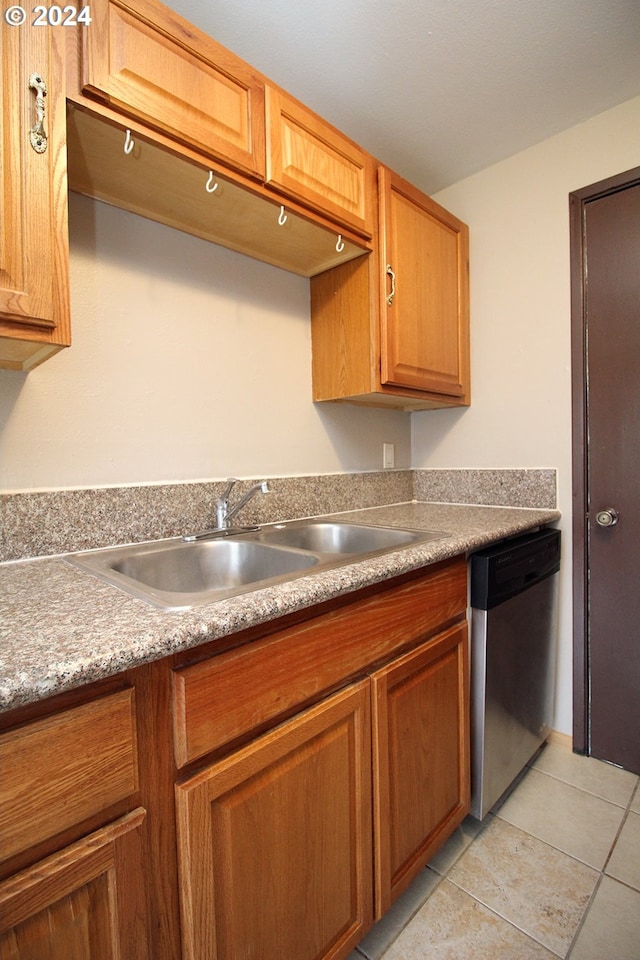 kitchen with dishwasher, sink, and light tile patterned flooring