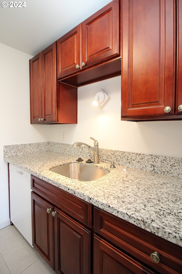 kitchen featuring light stone counters, sink, and light tile patterned floors