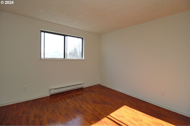 spare room with hardwood / wood-style floors, a textured ceiling, and baseboard heating