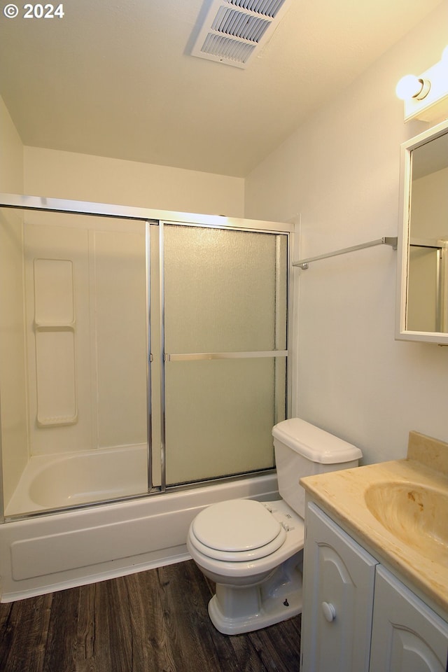 full bathroom with vanity, toilet, combined bath / shower with glass door, and wood-type flooring