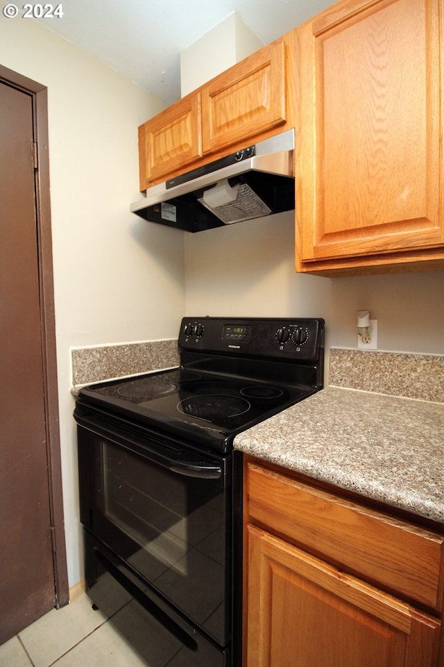 kitchen featuring light tile patterned flooring and black range with electric cooktop