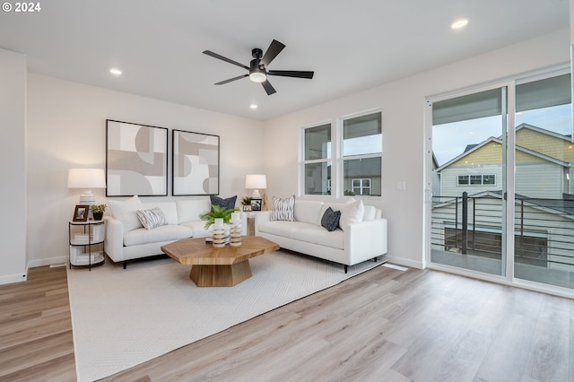 living room with light hardwood / wood-style floors and ceiling fan