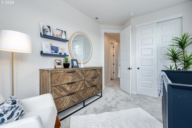 bedroom with light carpet and a closet