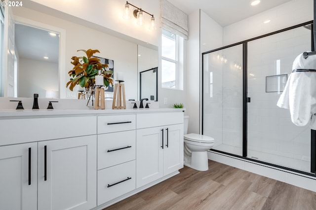 bathroom featuring vanity, toilet, hardwood / wood-style floors, and a shower with shower door