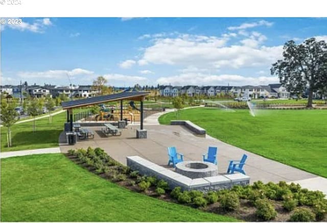 view of community with a yard, a gazebo, a patio, and an outdoor fire pit