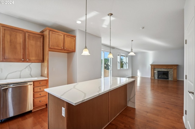 kitchen with tasteful backsplash, light stone counters, dark wood-type flooring, dishwasher, and hanging light fixtures