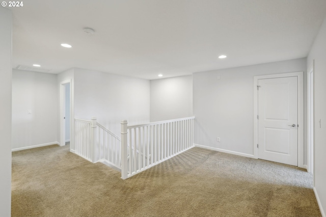 spare room featuring light carpet