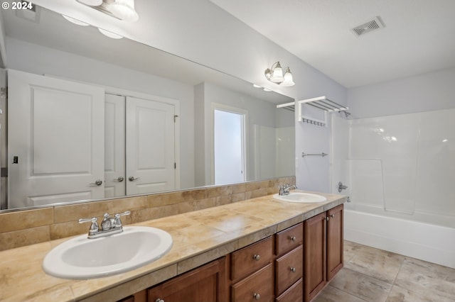 bathroom with decorative backsplash, bathtub / shower combination, and vanity