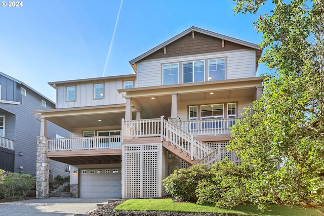 view of front of home featuring a garage, driveway, stairs, a porch, and board and batten siding