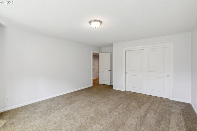 unfurnished bedroom featuring carpet flooring and a closet