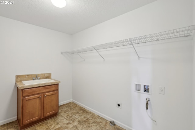 clothes washing area with cabinets, washer hookup, a textured ceiling, electric dryer hookup, and sink