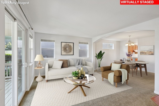 carpeted living room with a notable chandelier and a wealth of natural light