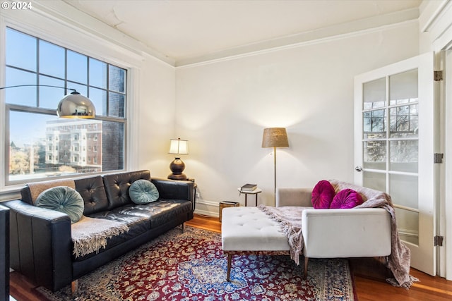 living room with hardwood / wood-style flooring and crown molding