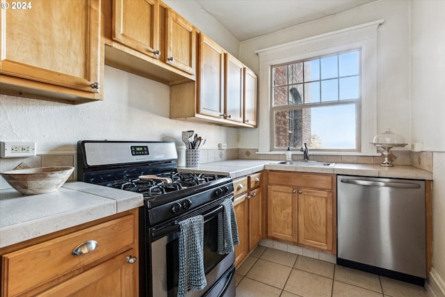 kitchen with light tile patterned flooring, stainless steel appliances, and sink