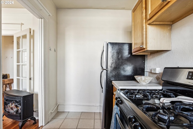 kitchen with gas range and light tile patterned flooring