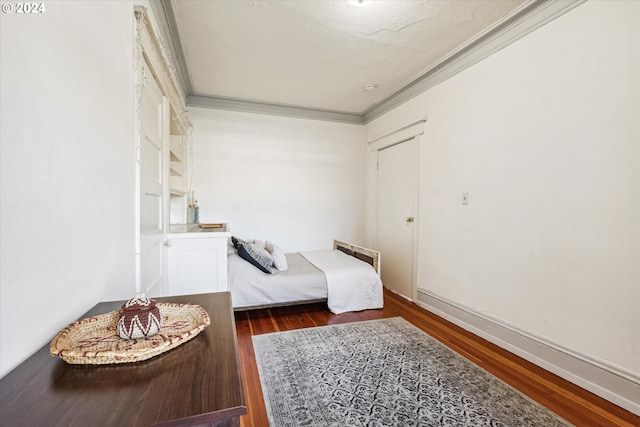 bedroom with crown molding and dark wood-type flooring