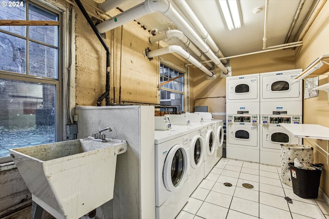 laundry room with washer and dryer, light tile patterned flooring, sink, and stacked washer and clothes dryer