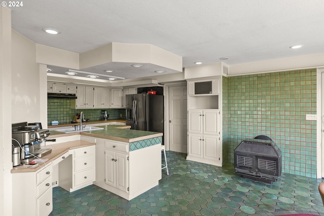 kitchen with stainless steel refrigerator with ice dispenser, sink, dark tile floors, and backsplash