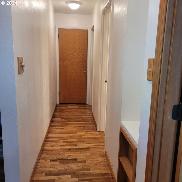 hallway with light hardwood / wood-style floors