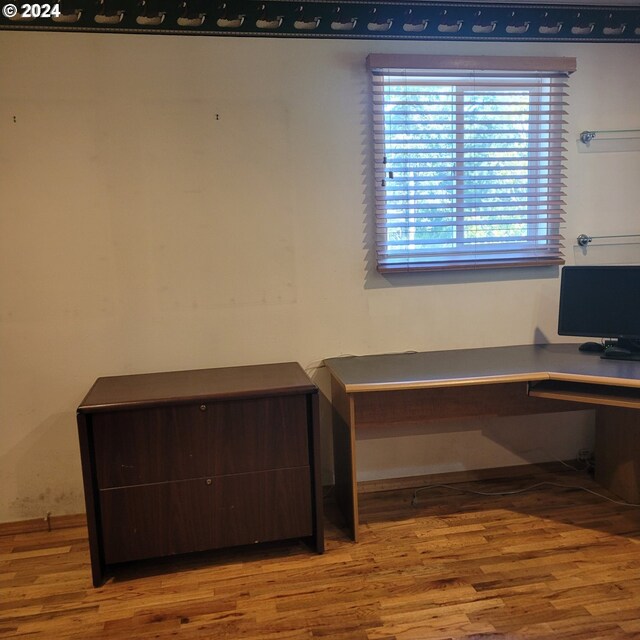 office area featuring wood-type flooring and built in desk