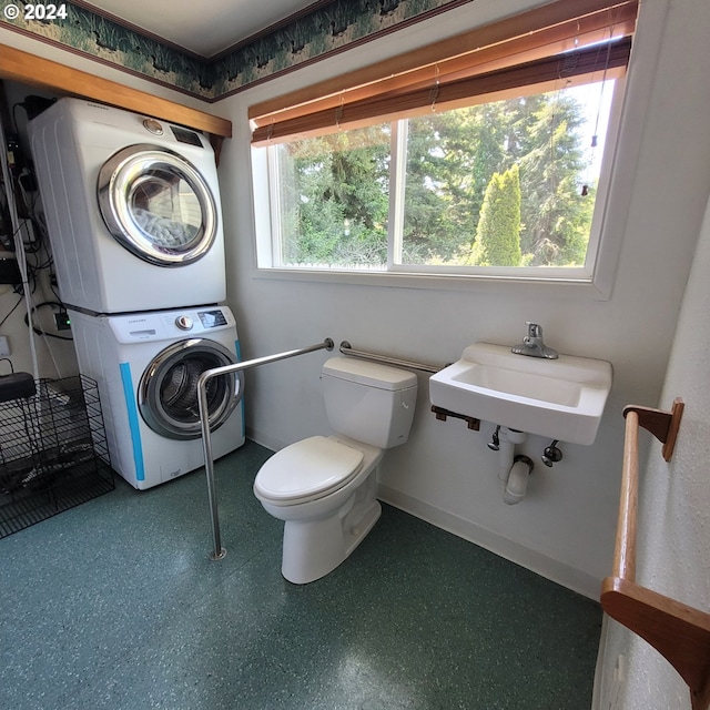 bathroom featuring stacked washer and dryer, sink, and toilet