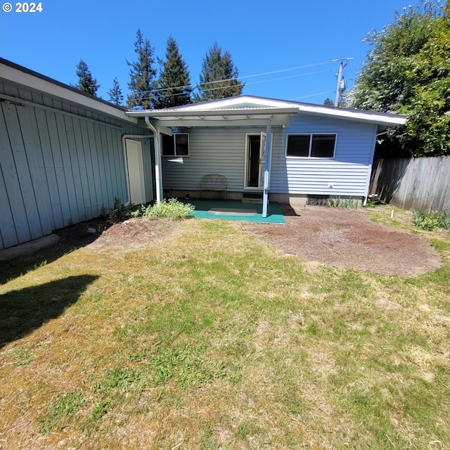 back of house featuring a patio and a yard