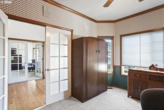 carpeted office with ceiling fan, ornamental molding, and french doors