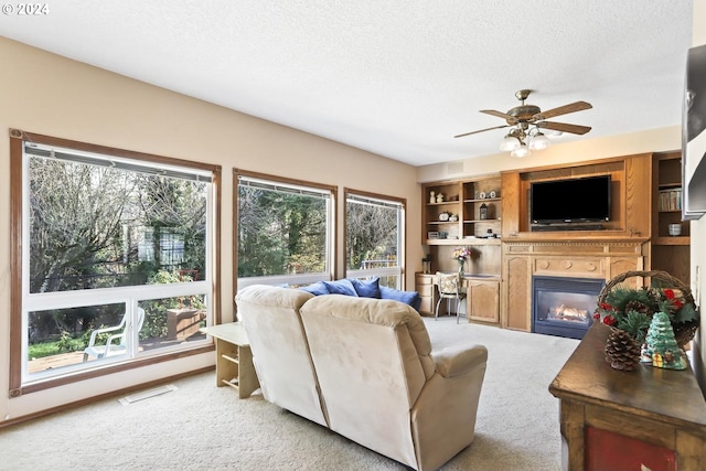 living room with ceiling fan, light colored carpet, and a wealth of natural light