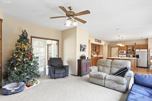 carpeted living room featuring ceiling fan