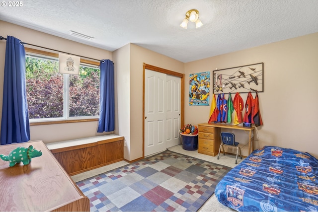bedroom with a textured ceiling and a closet