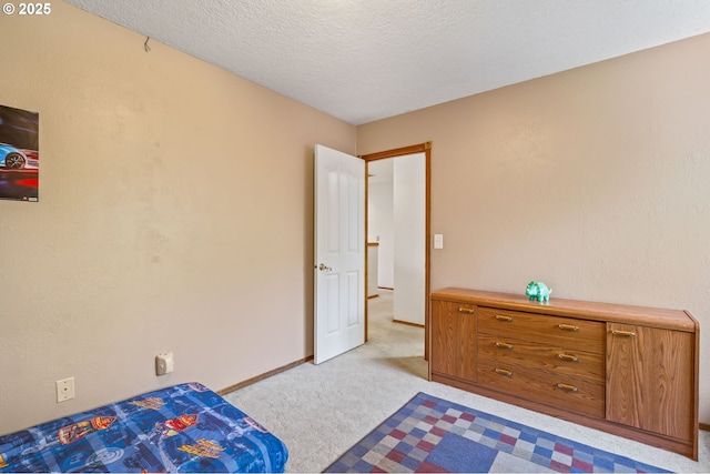 bedroom featuring carpet, baseboards, and a textured ceiling