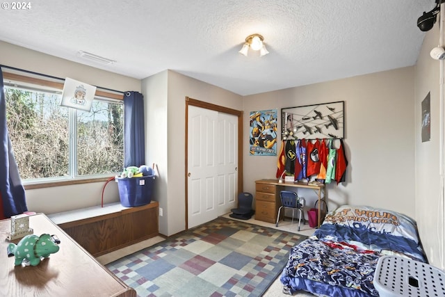 bedroom with a textured ceiling and a closet