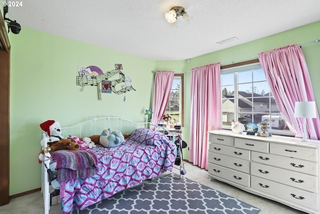 bedroom with a textured ceiling and light colored carpet