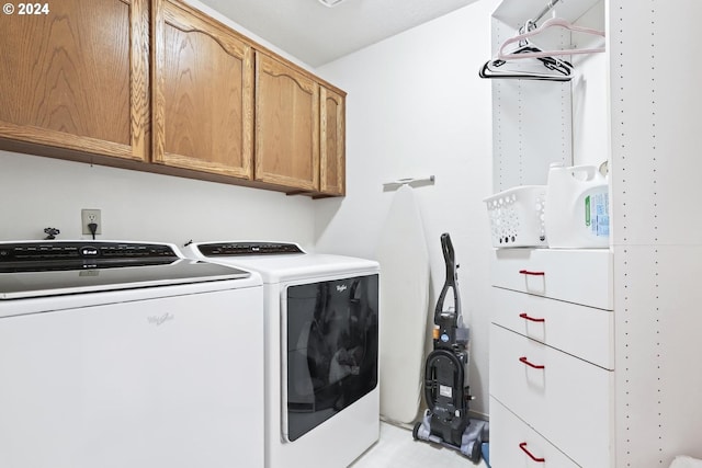 washroom with washer and dryer and cabinets