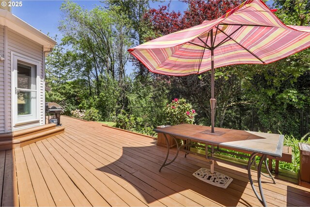 wooden deck featuring area for grilling and outdoor dining area
