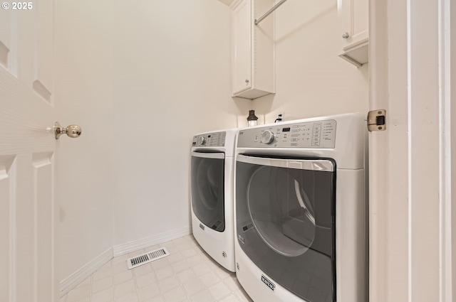 washroom featuring cabinet space, washing machine and clothes dryer, visible vents, and baseboards